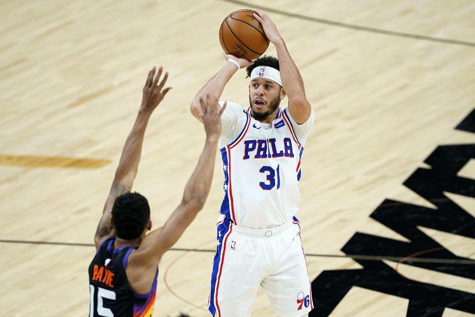 Philadelphia 76ers guard Seth Curry (31) shoots over Phoenix Suns guard Cameron Payne (15) during the first half of an NBA basketball game, Saturday, Feb. 13, 2021, in Phoenix.(AP Photo/Matt York)