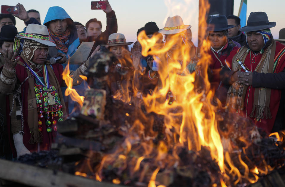 Indígenas aymaras queman ofrendas en honor a la Pachamama o Madre Tierra, después de recibir los primeros rayos de sol en un ritual de Año Nuevo en la montaña Murmutani en las afueras de Hampaturi, Bolivia, la madrugada del miércoles 21 de junio de 2023. (AP Foto/Juan Karita)