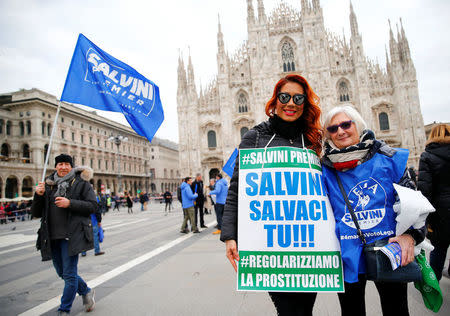Italian Norther League supporters hold a banner reading "Salvini saves us - Regulate prostitution" before the start of a political rally led by leader Matteo Salvini in Milan, Italy February 24, 2018. REUTERS/Tony Gentile