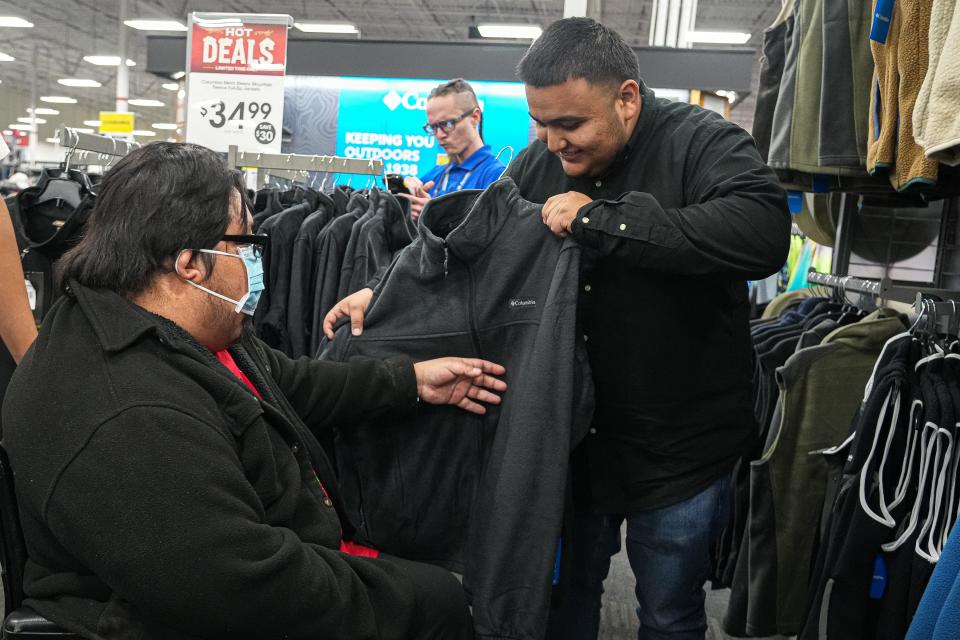 Jacob Jimenez, right, helps Joey Jimenez pick out a new sweater at Academy Sports & Outdoors. The family needs home repairs to improve accessibility.