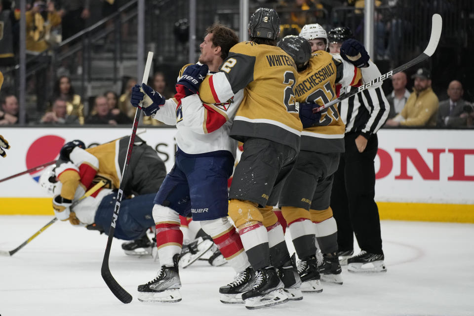 Vegas Golden Knights defenseman Zach Whitecloud (2) holds back Florida Panthers center Nick Cousins from fighting during the first period of Game 1 of the NHL hockey Stanley Cup Finals, Saturday, June 3, 2023, in Las Vegas. (AP Photo/John Locher)
