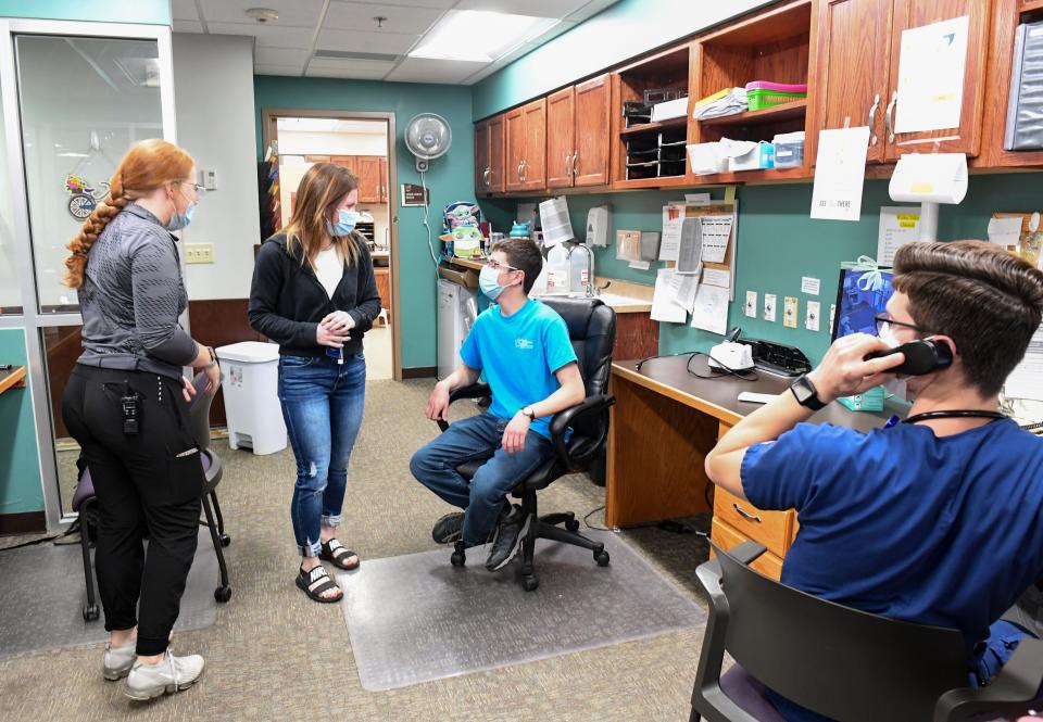 Blake Hammer, graduating senior at Roosevelt, chats with CNA Taylor Reierson and clinical care leader Kayla Finzen at the nurse's station on Wednesday, May 18, 2022, at Good Samaritan nursing home in Sioux Falls.