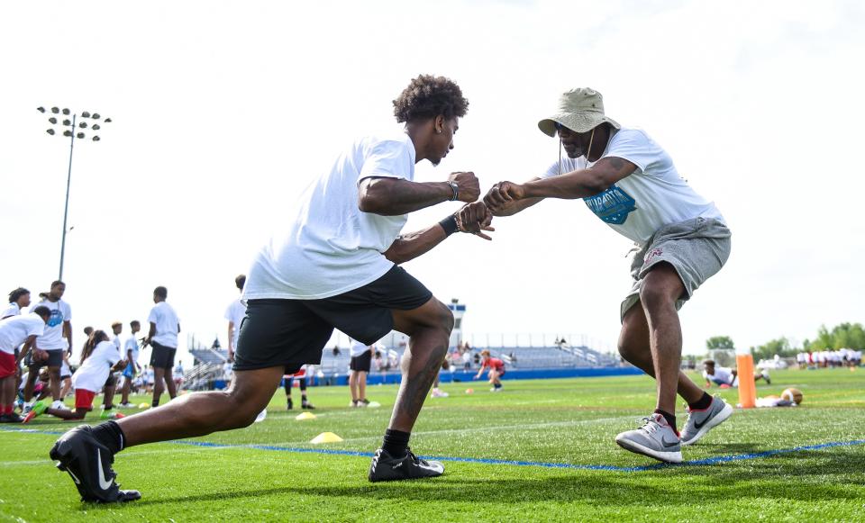 Former Carolina Panthers and Chicago Bears NFL WR Muhsin Muhammad, right, works on a drill with Michigan State WR Sebastian Brown,  Saturday, June 25, 2022, during the Taylor Moton 517 Football Camp at the Hope Sports Complex in Lansing. Muhammad and Brown were volunteering at the camp.