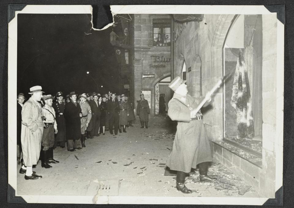 This photo released by Yad Vashem, World Holocaust Remembrance Center, shows German Nazis and civilians watch ransacking of Jewish property during Kristallnacht intake most likely in the town of Fuerth, Germany on Nov. 10, 1938. Israel’s Yad Vashem Holocaust memorial has acknowledged that a series of photos from Nazi Germany’s 1938 pogroms against Jews have been seen and published before, revising a claim it made when releasing the photos last week. They have been previously seen, on Twitter, in a research publication, and a recent PBS documentary. On Sunday, Nov. 13, 2022 Yad Vashem clarified its error in reply to a query from the AP. (Yad Vashem via AP)