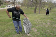 Kansas City, Kan. mayor Tyrone Garner collects trash while helping volunteers clean a neighborhood park Friday, April 22, 2022, in Kansas City, Kan. Garner was elected in last November becoming the city's first Black mayor and has created a committee that would propose police reforms. (AP Photo/Charlie Riedel)