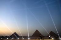 FILE PHOTO: People take pictures in front of the Great Pyramids in Giza