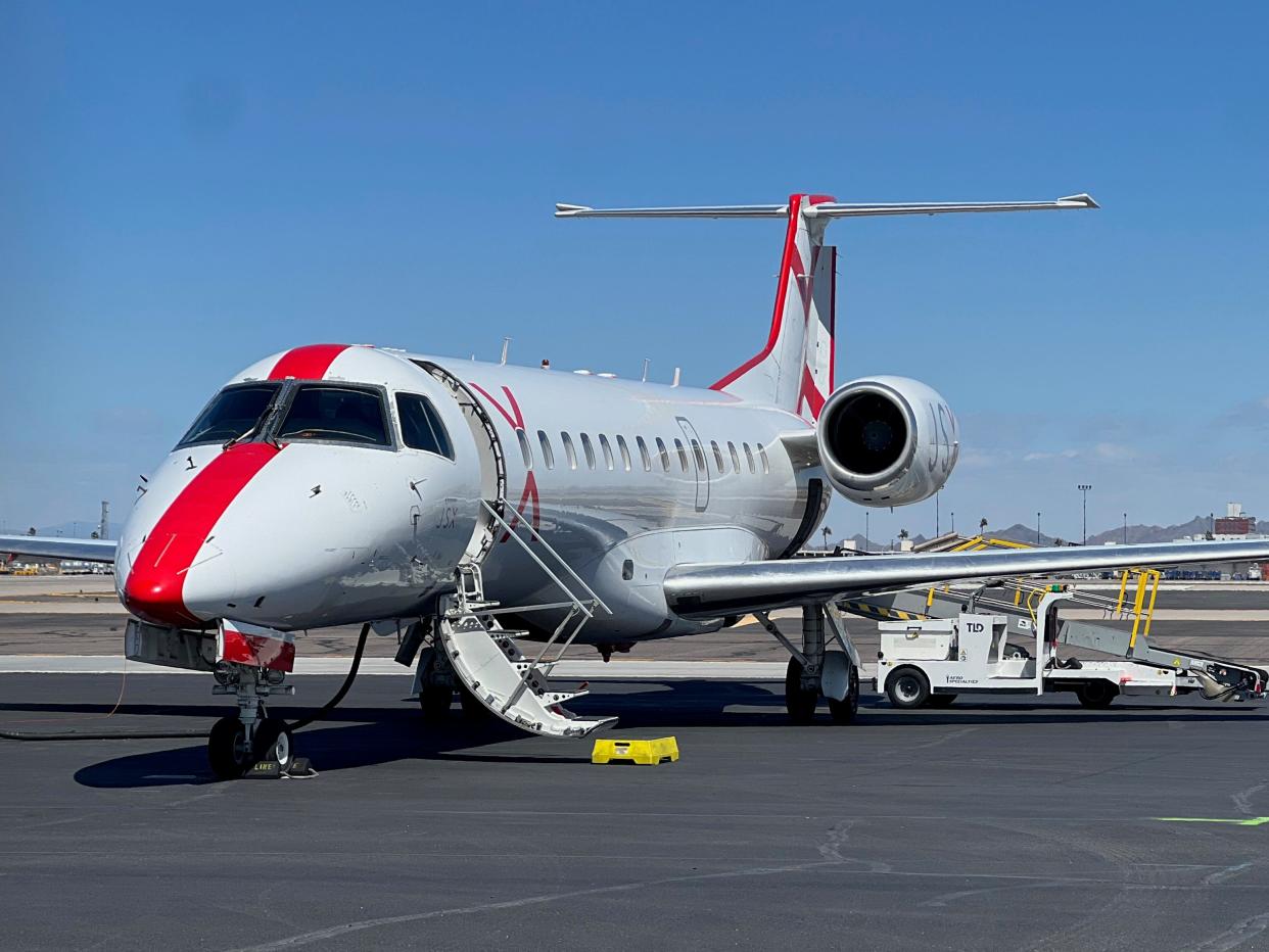 A JSX aircraft with its boarding door open on a runway in Phoenix.