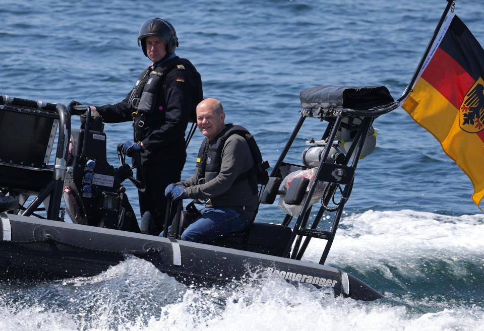 Men stand on a  speedboat.