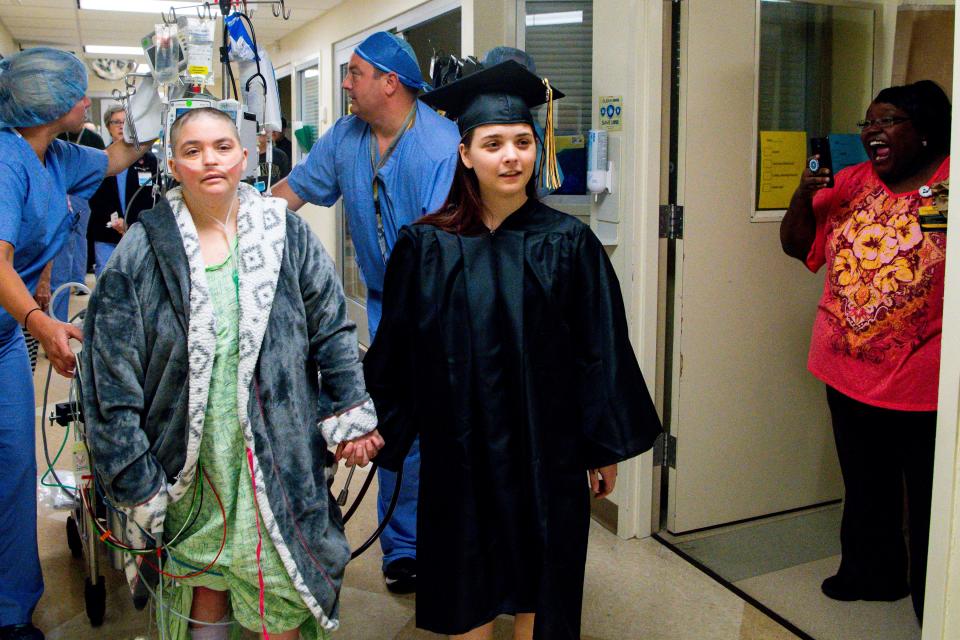 Jaszmon Perez takes her mother, Bridget Perez, on a lap around the hospital floor during a special graduation at Vanderbilt University Medical Center Tuesday, May 21, 2019, in Nashville, Tenn. Bridget Perez, 36, is on ECMO waiting for a lung transplant and wouldn't have been able to attend the graduation.