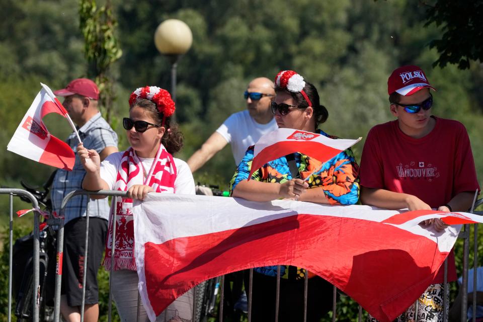 People wait for a massive military parade during the Polish Army Day (AP)