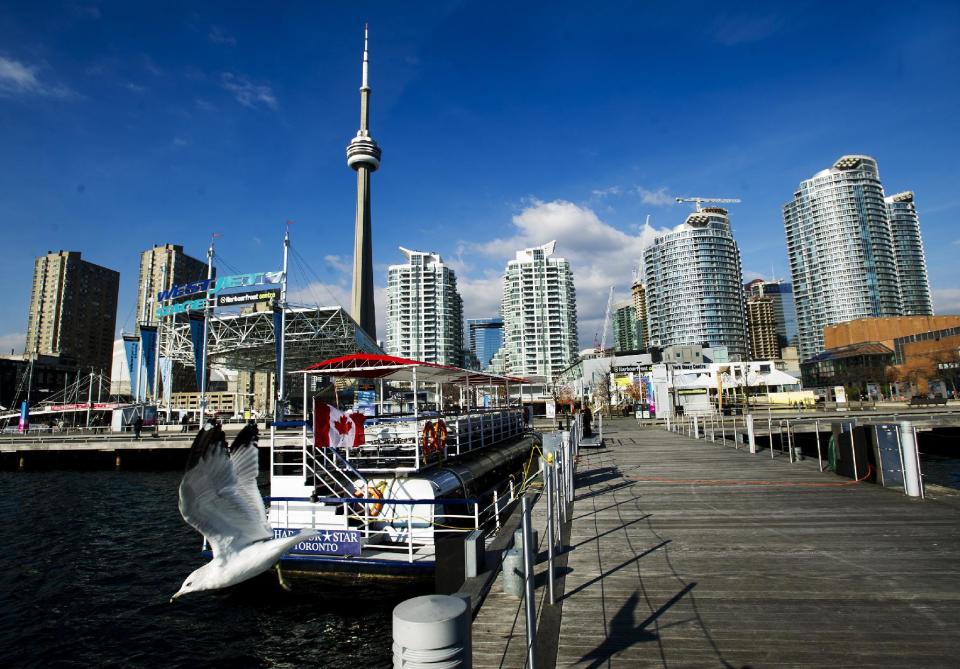 This Nov. 14, 2012 photo shows a seagull taking flights along the board walk at Toronto's Harbour Front in Toronto. The Harbourfront Centre's 10-acre lakeside site hosts over 4,000 events, a large majority of which are gratis. The arts and culture hub's York Quay Center and The Power Plant have changing arts and photo exhibits year-round for no entry fee. (AP Photo/The Canadian Press, Nathan Denette)