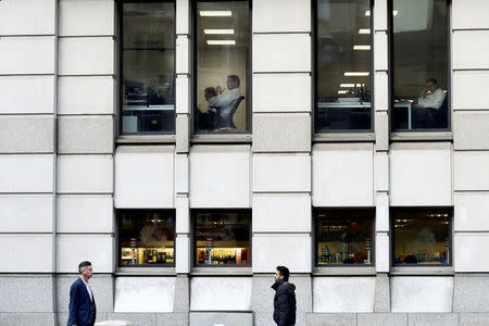 City workers sit at their desks in the early hours in the City of London, Britain October 17, 2017. Picture taken October 17, 2017. REUTERS/Mary Turner