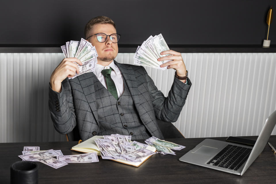 A man fanning himself with cash