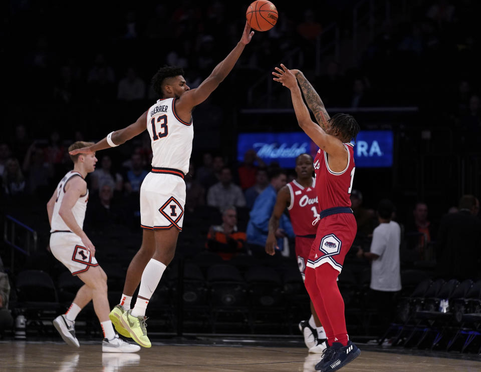 A shot by Florida Atlantic guard Alijah Martin is blocked by Illinois forward Quincy Guerrier (13) during the first half of an NCAA college basketball game in New York, Tuesday, Dec. 5, 2023. (AP Photo/Peter K. Afriyie)