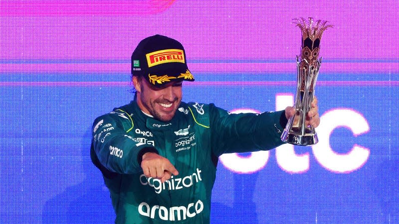 A photo of Fernando Alonso holding his F1 trophy. 