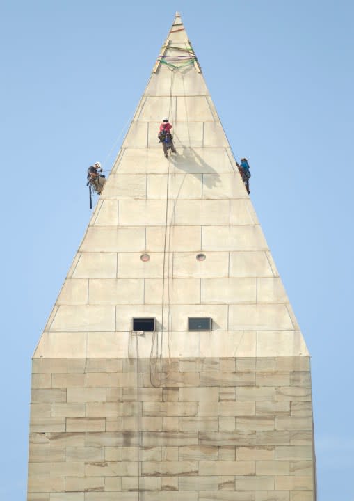 A team of engineers, from left, Dan Gach, Emma Cardini, center, and Katie Francis, harnessed to ropes , inspect the exterior of the Washington Monument for damage caused by last month’s earthquake, Wednesday, Sept. 28, 2011, in Washington. (AP Photo/Evan Vucci)