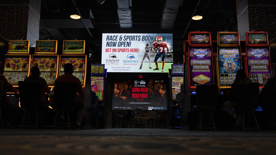 FILE - A huge TV screen at the entrance of Churchill's Bourbon & Brew Bar & Grille, flanked by electronic gaming machines, promotes sports betting at Turfway Park Racing & Gaming, Dec. 22, 2023, in Florence, Ky. A bill that would allow sports betting in Georgia under the purview of the state lottery advanced out of committee Tuesday, Jan. 30, 2024, moving on to the full Senate for more debate. (AP Photo/Carolyn Kaster, File)