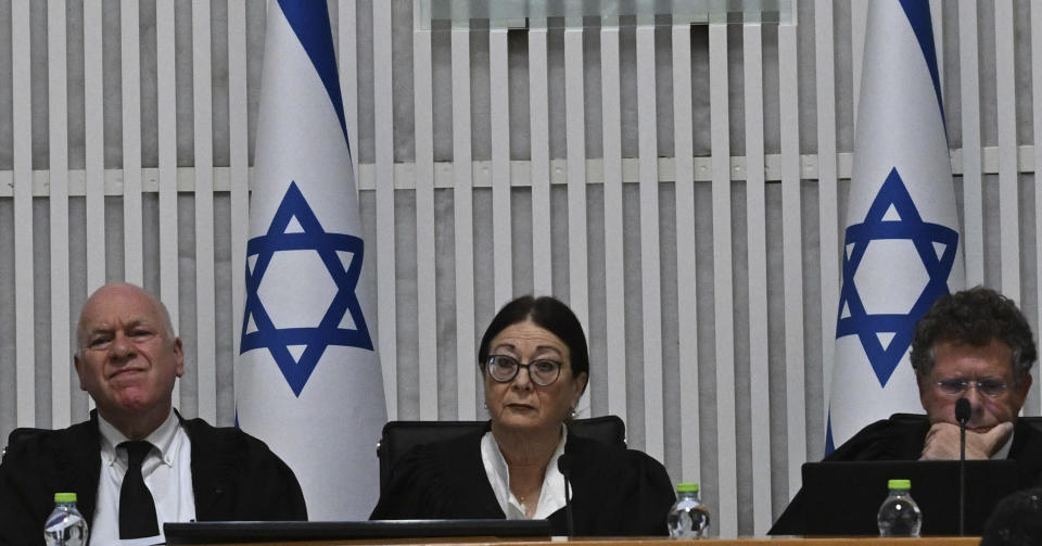 Esther Hayut, chief justice of the Supreme Court of Israel, center, sits on the bench with justices Uzi Vogelman, left, and Issac Amit, right, during a session with all of Israel's Supreme Court justices for the first time in the country's history to look at the legality of Prime Minister Benjamin Netanyahu's contentious judicial overhaul, which the government pushed through parliament in July, in Jerusalem, Tuesday, Sept. 12, 2023. The divisive law, which cancels the court's ability to block government actions and appointments using the legal concept that they are "unreasonable," is the first piece of the wider government plan to weaken the Supreme Court. (Debbie Hill/Pool Photo via AP)