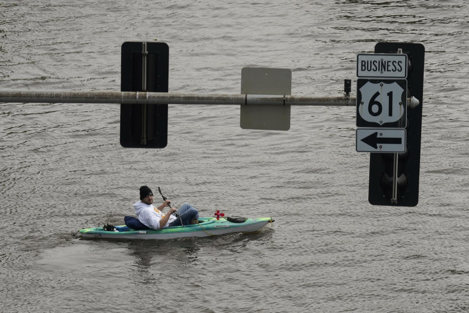 A kayaker floats down a flooded street, Monday, May 1, 2023, in downtown Davenport, Iowa. (AP Photo/Charlie Neibergall)