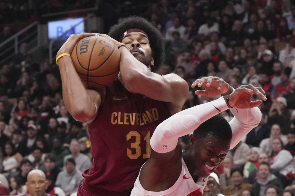 Cleveland Cavaliers' Jarrett Allen (31) claims a defensive rebound from Toronto Raptors' Dennis Schroder during the first half of an NBA basketball game in Toronto, Monday, Jan. 1, 2024. (Chris Young/The Canadian Press via AP)