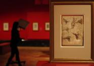 An employee of the Queen's Gallery moves a light in the background as a pen, ink and black charcoal drawing by Leonardo da Vinci titled 'The Muscles of the Shoulder ', around-1510-12, is seen at the Anatomist- exhibition at the Queen's gallery in Buckingham Palace, London, Monday, April 30, 2012. The display the largest ever of da Vinci's anatomical works is open to the public and runs from May 4- Oct. 7. (AP Photo/Alastair Grant)