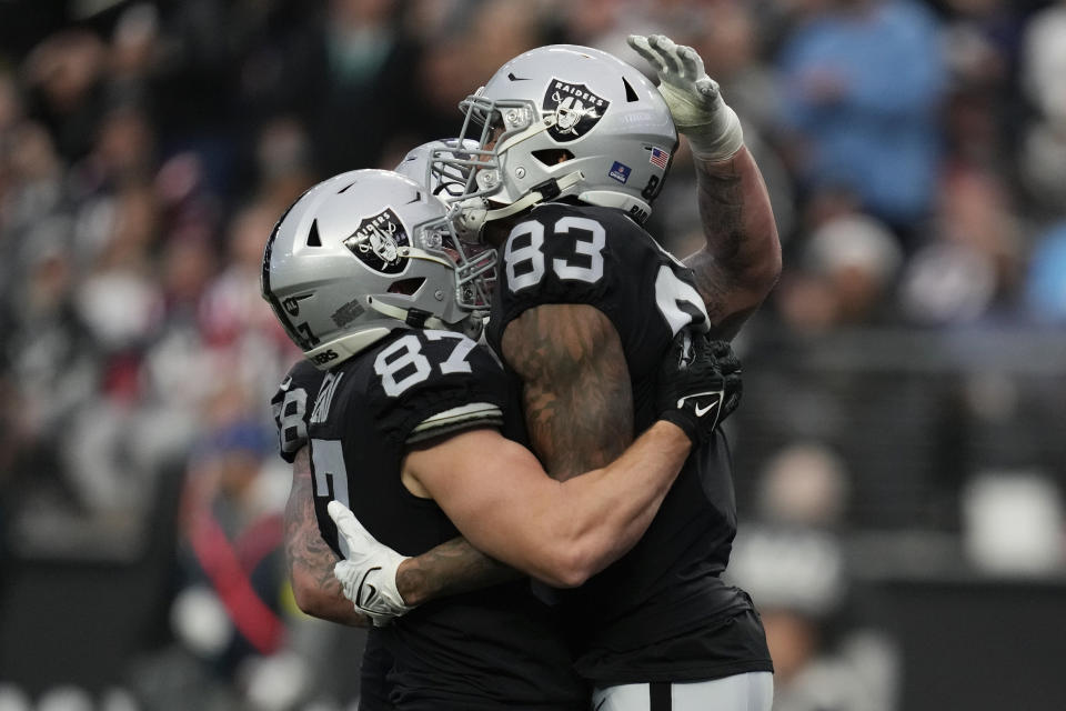 Las Vegas Raiders tight end Darren Waller (83) is congratulated by teammates after scoring on a 25-yard pass during the first half of an NFL football game between the New England Patriots and Las Vegas Raiders, Sunday, Dec. 18, 2022, in Las Vegas. (AP Photo/John Locher)