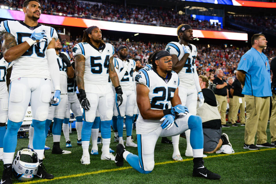 Eric Reid kneels on the sideline during the national anthem.