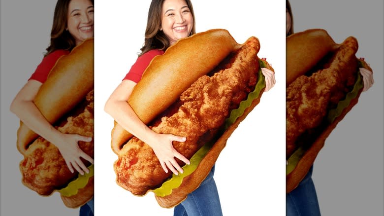 A woman holding a Chick-fil-A sandwich pillow