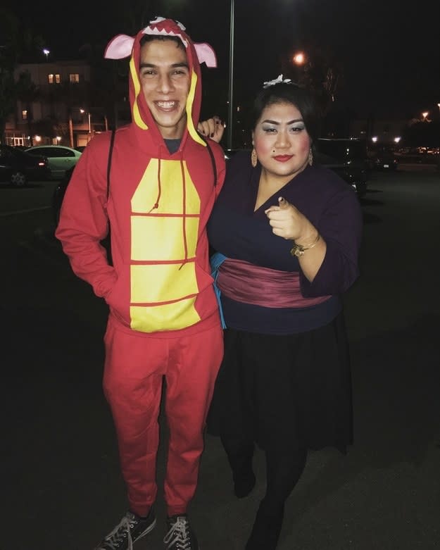 Someone in a red-and-yellow dragon costume and another dressed as the Matchmaker, with heavy makeup