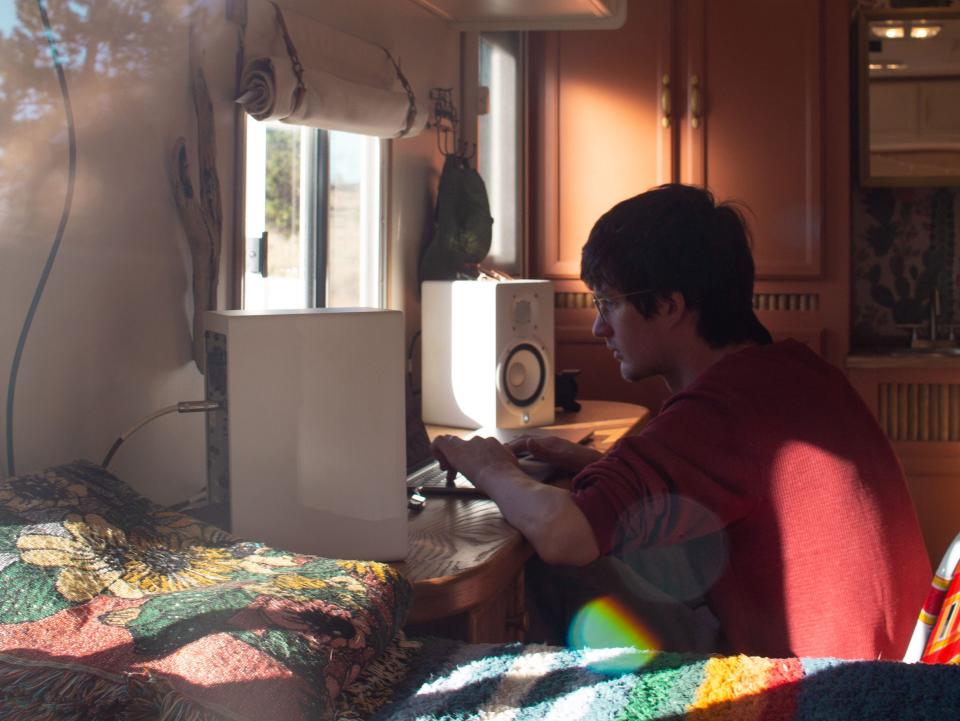 Brandon Smith working at the desk in their trailer.