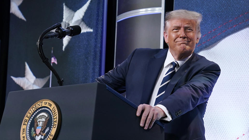 President Trump smiles from a podium