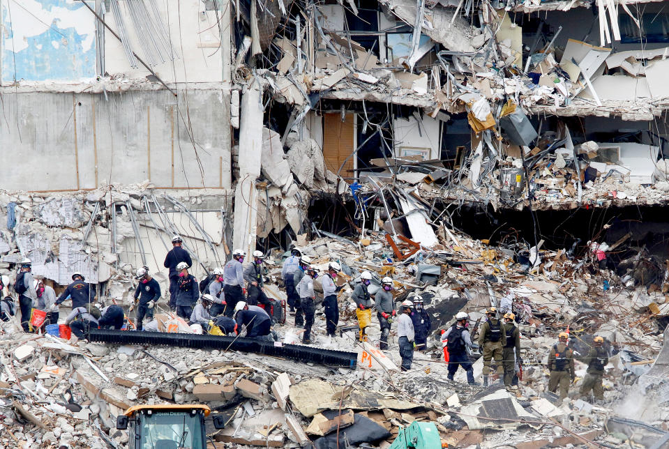 Image: Emergency workers conduct search and rescue efforts at the site of a partially collapsed residential building in Surfside (Joe Skipper / Reuters)