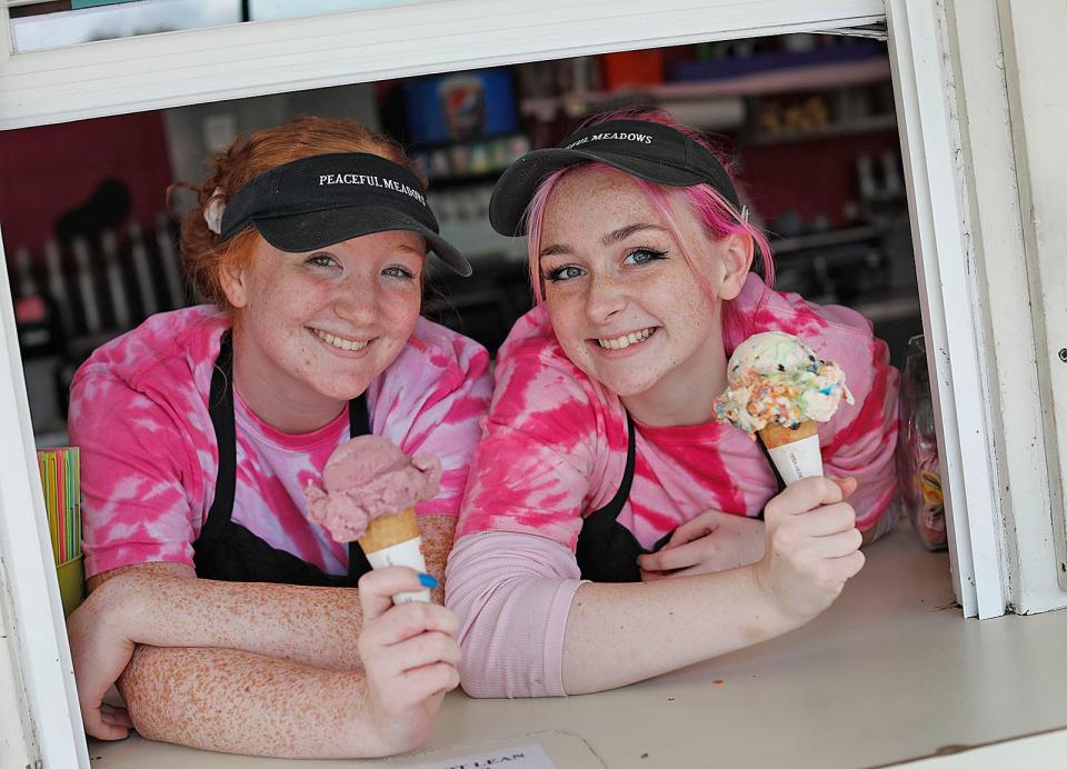 Luci Schneider with black raspberry and Rebecca Killion with M&M ice cream hold freshly scooped cones at Peaceful Meadows in Whitman on Wednesday, Aug. 11, 2021.