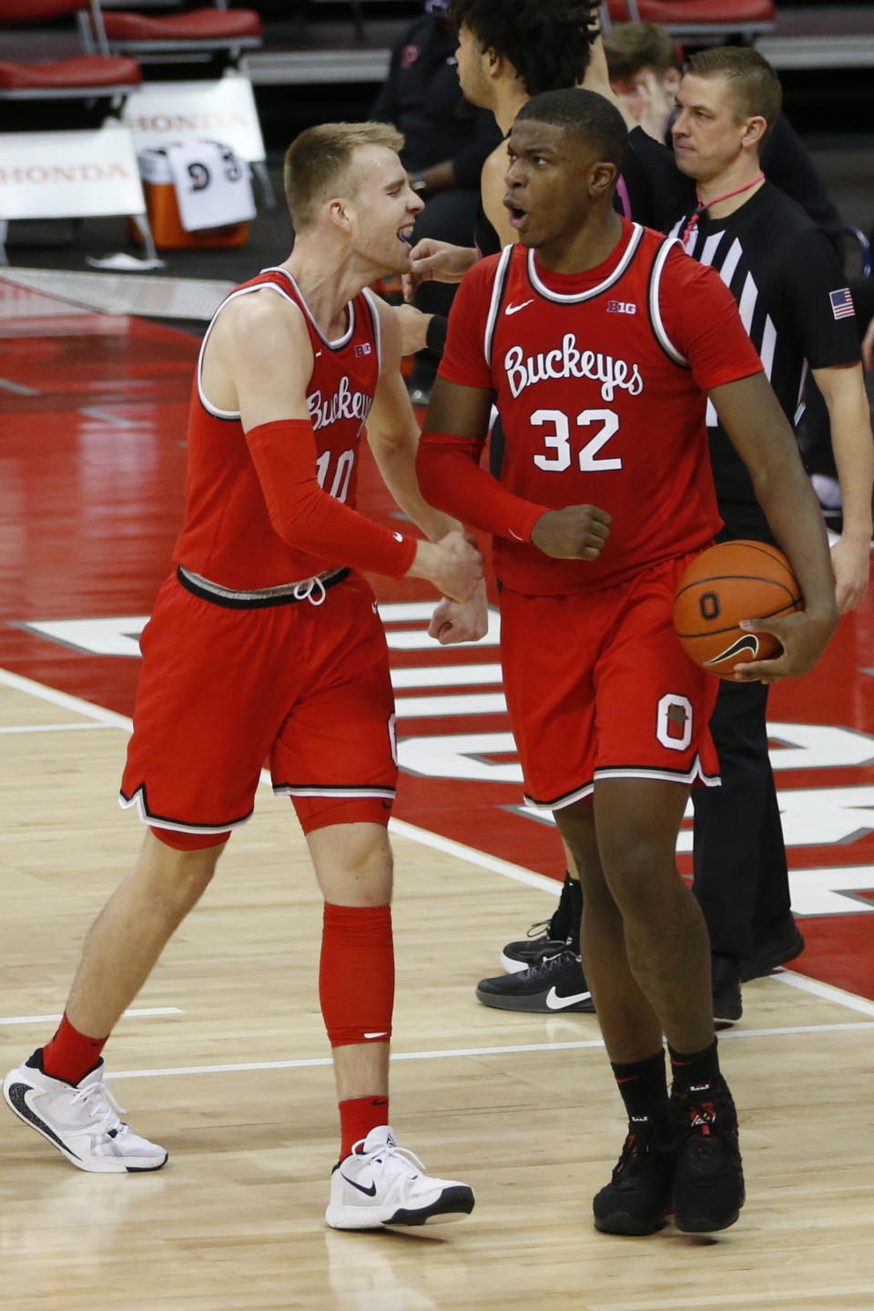 Ohio State's E.J. Liddell, right, celebrates grabbing with teammate Justin Ahrens during the second half of an NCAA college basketball game Wednesday, Jan. 27, 2021, in Columbus, Ohio. Ohio State beat Penn State 83-79. (AP Photo/Jay LaPrete)