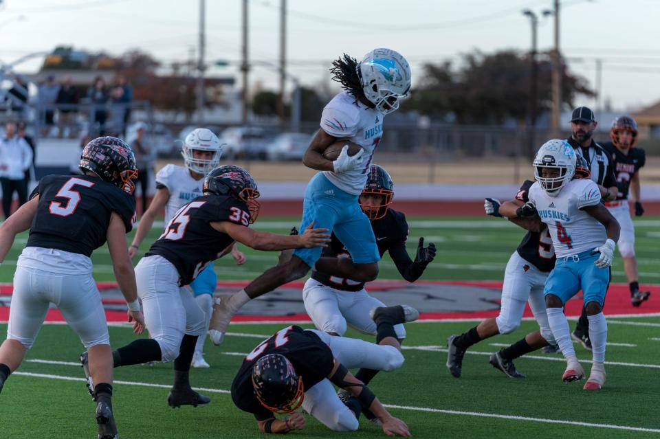 Hirschi's Jewel Fletcher leaps over a Dumas defender Friday, November, 26, 2021, at Sherwood Memorial Stadium in Plainview.