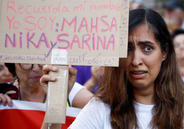 PHOTO: A woman holds a sign bearing the names of slain Iranian women including Nika Shakarami during a protest against the Islamic regime of Iran and the death of Mahsa Amini in front of the Iranian Embassy in Madrid, Oct. 6, 2022. (Juan Medina/Reuters)