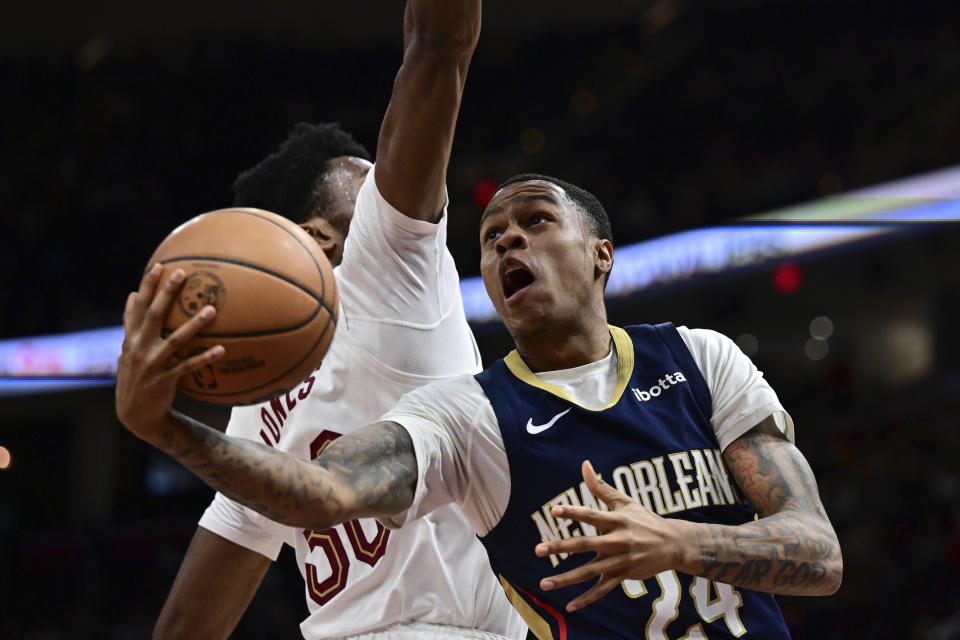 New Orleans Pelicans guard Jordan Hawkins goes to the basket against Cleveland Cavaliers center Damian Jones during the second half of an NBA basketball game Thursday, Dec. 21, 2023, in Cleveland. The Pelicans won 123-104. (AP Photo/David Dermer)