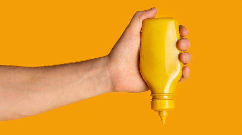 squeezing yellow mustard bottle