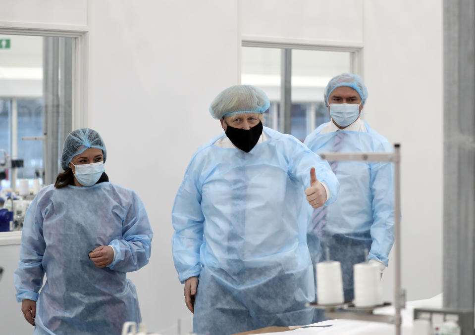 Britain's Prime Minister Boris Johnson, wearing a face mask to prevent the spread of the coronavirus, visits a PPE manufacturing facility during a visit to the north east of England, in Seaton Delaval, England, Saturday, Feb. 13, 2021. (AP Photo/Scott Heppell, Pool)
