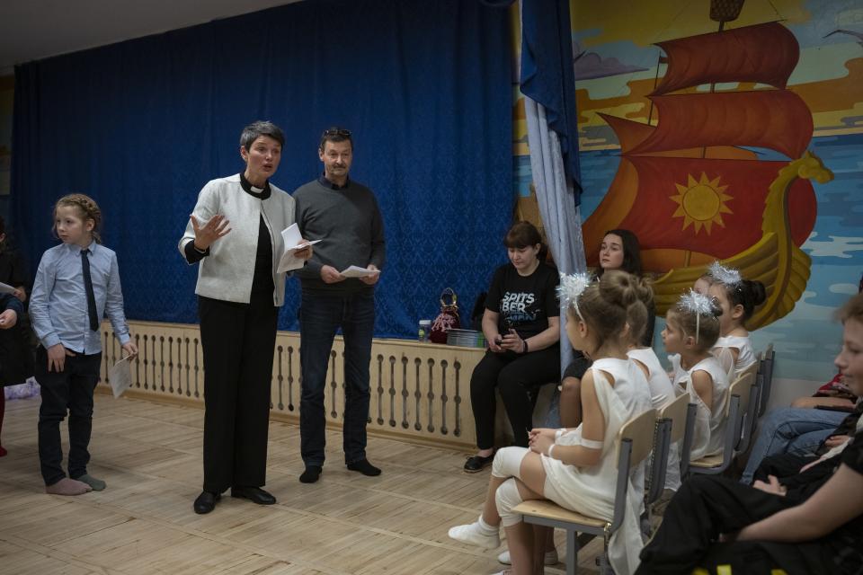 The Rev. Siv Limstrand speaks next to a translator, Stein-Magne Wiik, during a Christmas performance at the Barentsburg school in Barentsburg, Norway, Saturday, Jan. 7, 2023. (AP Photo/Daniel Cole)