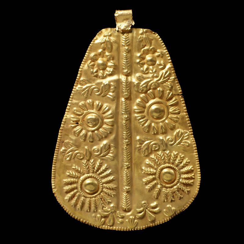 A repousse gold ornament for attachment to furniture or clothing is displayed in this undated handout picture