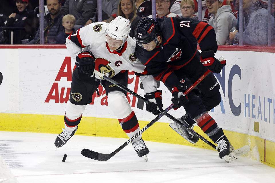 Carolina Hurricanes' Brett Pesce (22) vies for the puck against Ottawa Senators' Brady Tkachuk (7) during the first period of an NHL hockey game in Raleigh, N.C., Wednesday, Oct. 11, 2023. (AP Photo/Karl B DeBlaker)