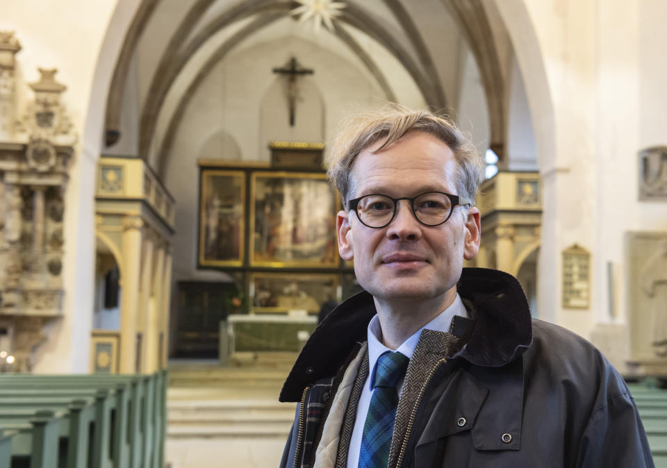 In this Tuesday, Jan. 14, 2020 photo pastor Johannes Block poses for a photo in the Stadtkirche (Town Church) in Wittenberg, Germany. The church contains a so-called “Judensau,” or “Jew pig,” sculpture which is located about 4 meters, 13 feet, above the ground on a corner of the Church. A court in eastern Germany will consider next week a Jewish man’s bid to force the removal of an ugly remnant of centuries of anti-Semitism from a church where Martin Luther once preached. (AP Photo/Jens Meyer)