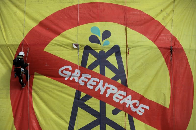 A Greenpeace activist hangs from an oil tank at the Hellenic Petroleum refineries in Aspropyrgos near Athens