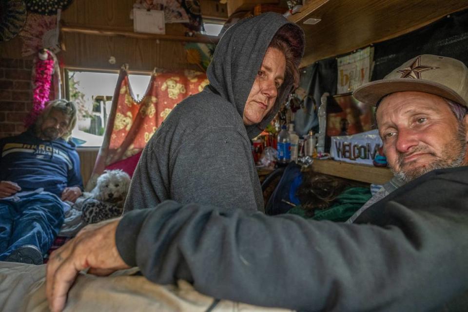 Tracy Ruberto, 50, center, and Anthony Ruberto, 49, right, talk about the challenges of being homeless – including losing their possessions and constantly being forced to move – inside their RV as friend Partick Hannigan, 59, and one of their dogs listened in November in North Highlands, near the parking lot planned to be a “Safe Stay” site for the homeless.