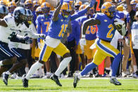 Pittsburgh running back Israel Abanikanda (2) breaks away past Rhode Island defensive back O'Neil Robinson (9) on his way for a long run touchdown during the first half of an NCAA college football game, Saturday, Sept. 24, 2022, in Pittsburgh. (AP Photo/Keith Srakocic)