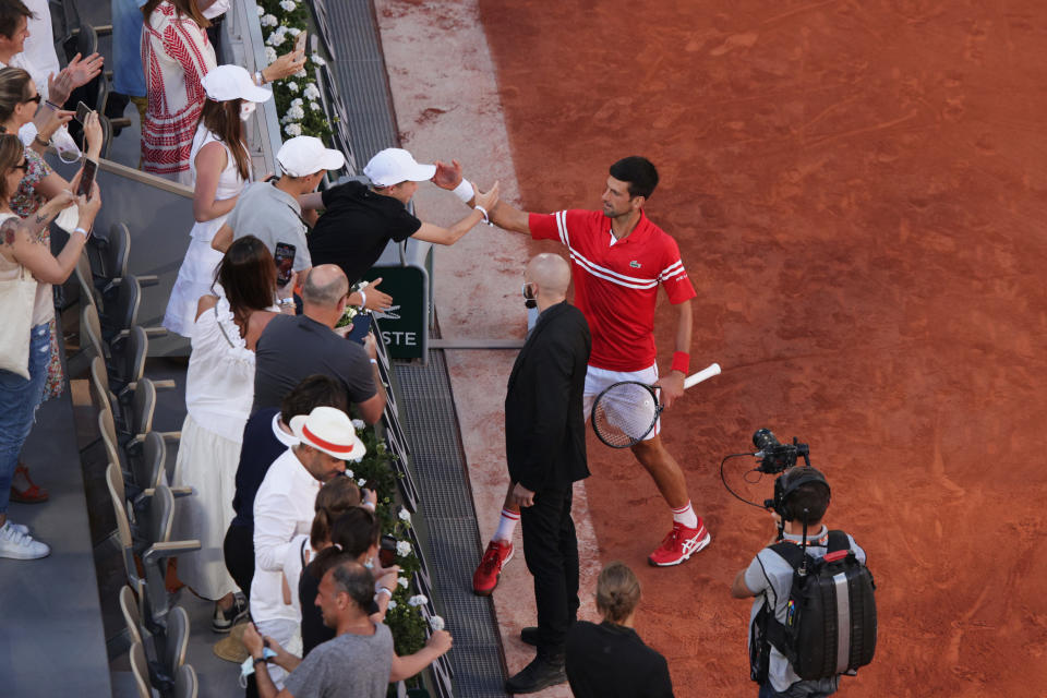 Tournament winner Novak Djokovic (pictured right) celebrates with a fan after winning his Men's Singles Final match at Roland Garros on June 13, 2021 in Paris, France.