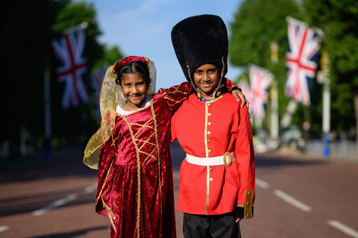 Royal fans Caellia (L) and Yoshilen wear costumes as they arrive at the Mall to celebrate the first day of celebrations to mark the Platinum Jubilee of Queen Elizabeth II on June 02, 2022, in London, England.