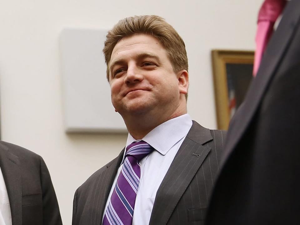 four men in suits and ties talk and two shake hands on capitol hill