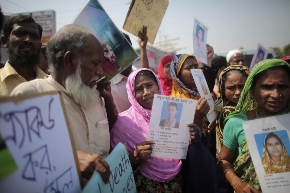 Relatives of victims killed in the collapse of Rana Plaza hold pictures on the first year anniversary of the accident, as they gather in Savar April 24, 2014. Protesters and family members of victims demand compensation on the one year anniversary of the collapse of Rana Plaza, in which more than 1,100 factory workers were killed and 2,500 others were injured.